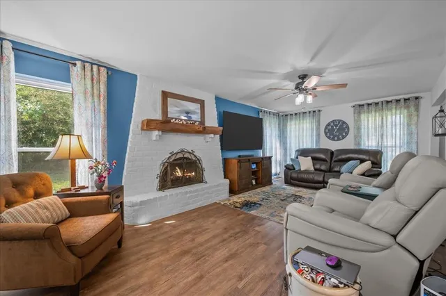 a living room with furniture a fireplace and a flat screen tv