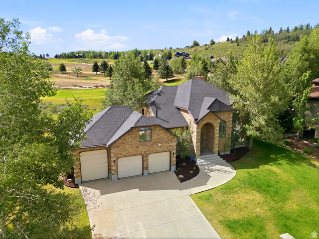 3535 Homestead Road Park City, UT 84098 - Photo 2 of 81 Stone-clad exterior featuring a prominent arched entry, a multi-car garage, and a dark shingle roof