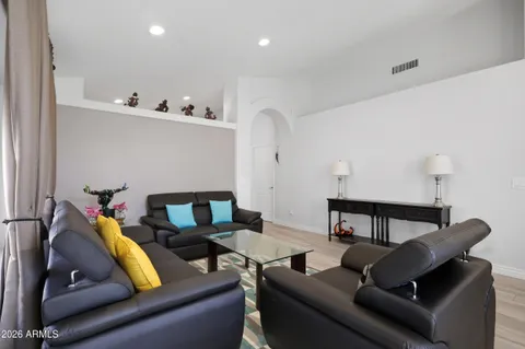 a living room with furniture and a wooden floor