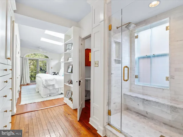a bathroom with a glass shower door and a window