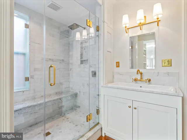 a bathroom with a shower sink and mirror