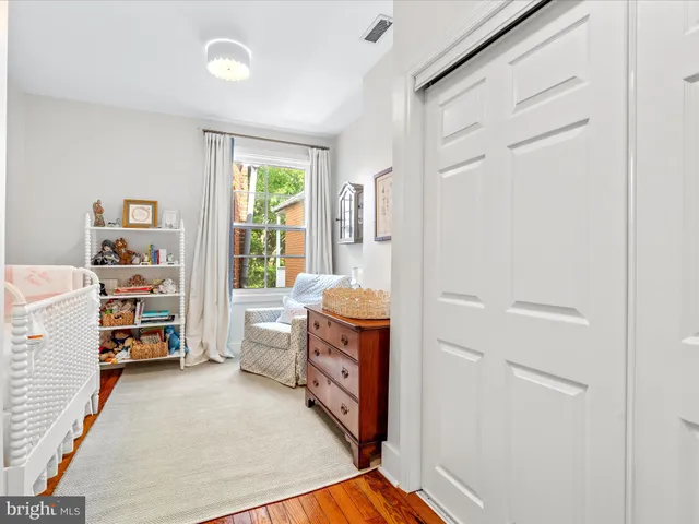 a room with a baby crib and a dresser