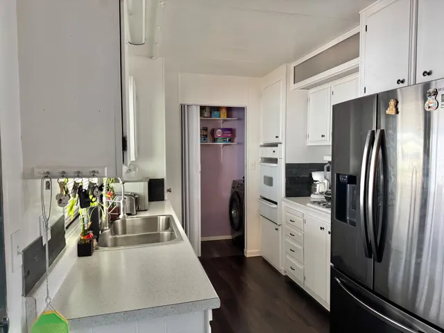 a kitchen with stainless steel appliances a refrigerator sink and white cabinets