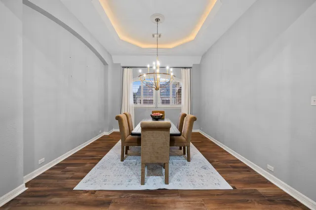a dining room with furniture a chandelier and wooden floor