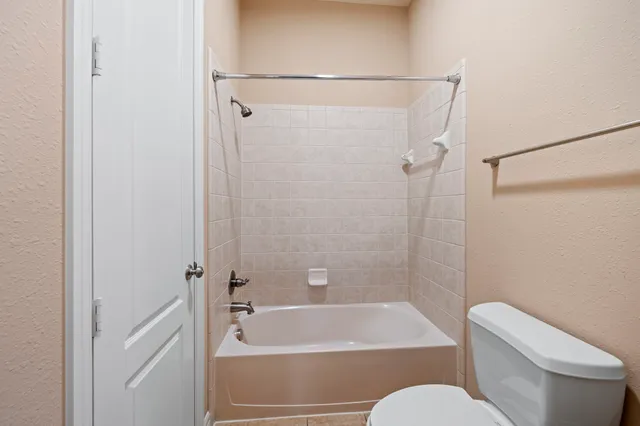 a bathroom with a toilet and a bath tub
