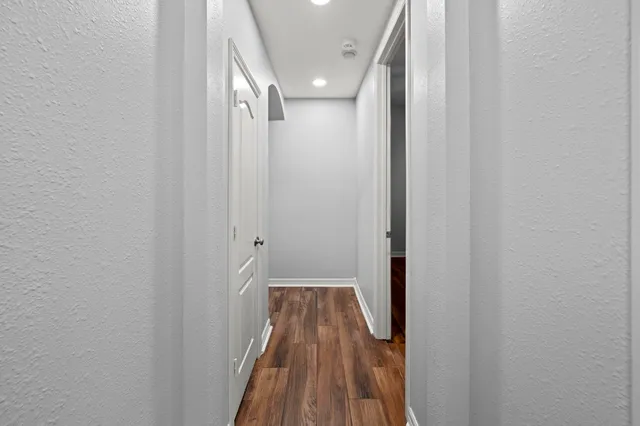 a view of a hallway with wooden floor and staircase
