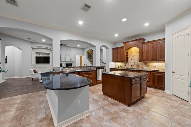 a large living room with stainless steel appliances granite countertop a couch and a view of living room