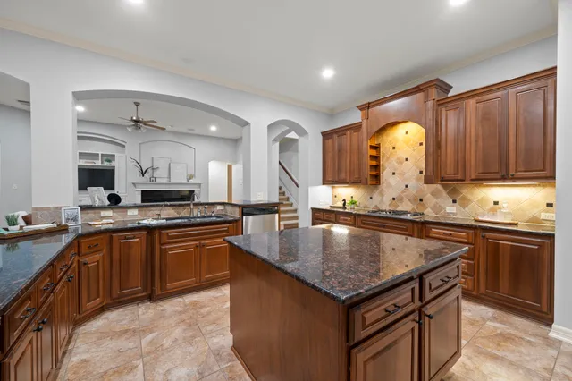 a kitchen with granite countertop a sink and a stove