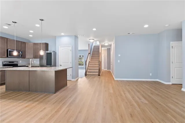 a kitchen with granite countertop a refrigerator oven a sink a counter space and cabinets