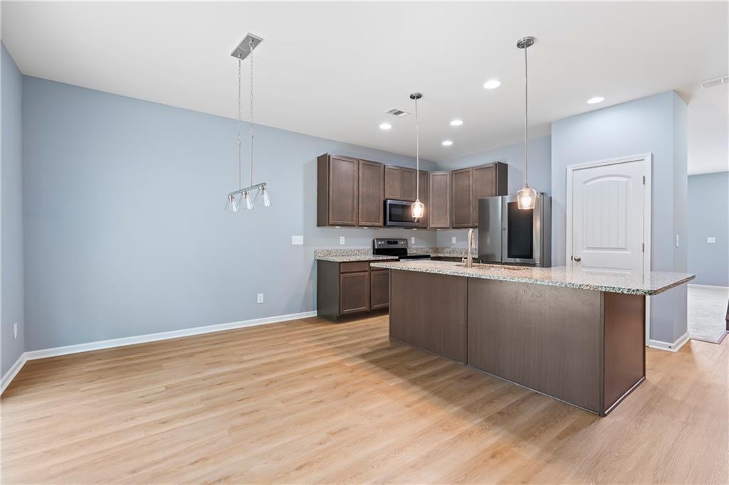 71 Moonrise Crossing Dallas, GA 30132 - Photo 5 of 64 a kitchen with granite countertop a refrigerator oven a sink a counter space and cabinets