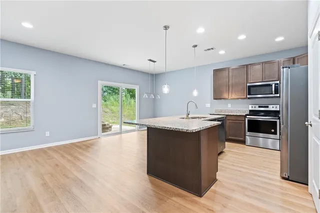 a kitchen with stainless steel appliances granite countertop sink microwave and refrigerator