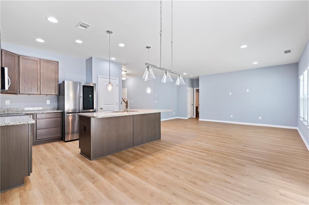 71 Moonrise Crossing Dallas, GA 30132 - Photo 7 of 64 a large kitchen with stainless steel appliances kitchen island a large counter top and a wooden floors