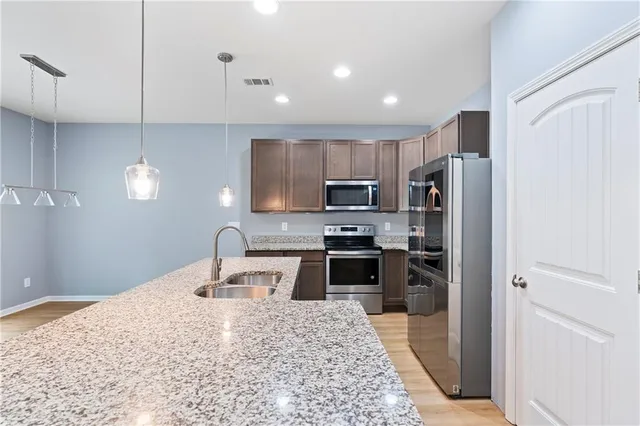 a kitchen with a sink a counter top space and stainless steel appliances