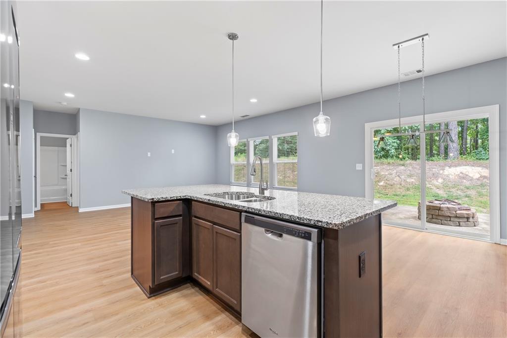 71 Moonrise Crossing Dallas, GA 30132 - Photo 10 of 64 a kitchen with stainless steel appliances granite countertop a sink a stove and a wooden floor