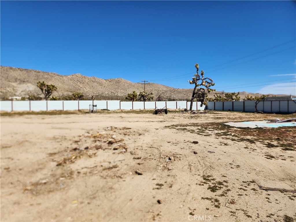 7248 Scarvan Road Yucca Valley, CA 92284 - Photo 3 of 6 a view of dirt yard with a table and chairs