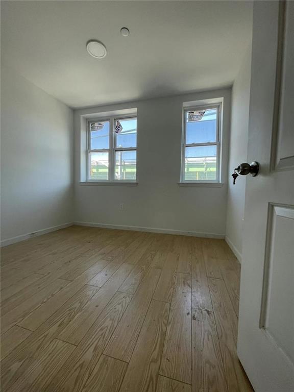 4313 3rd Avenue Brooklyn, NY 11232 - Photo 3 of 5 an empty room with wooden floor and windows