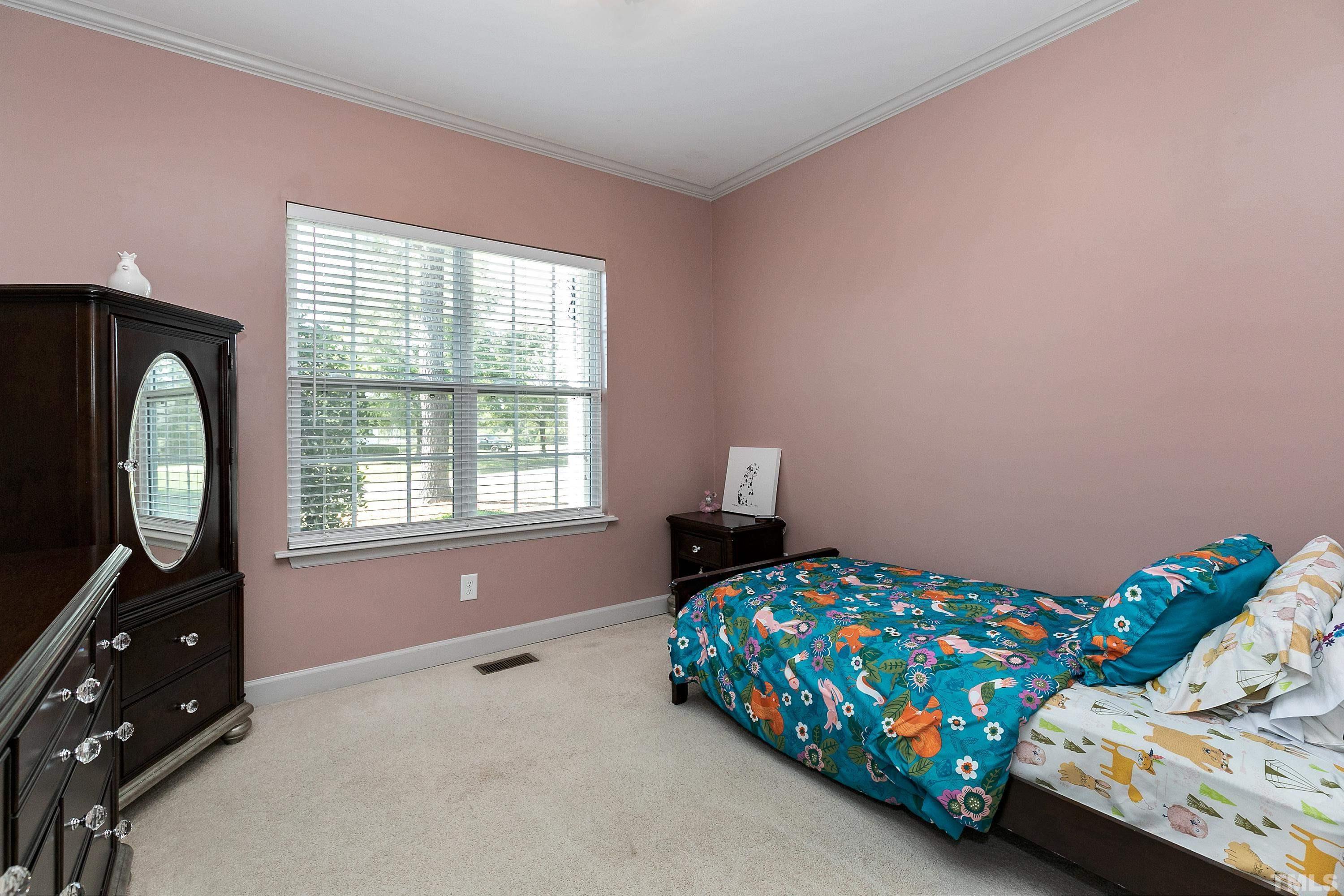 7025 Onslow Stephenson Road Willow Spring, NC 27592 - Photo 17 of 30 a bedroom with a bed a dresser and a window