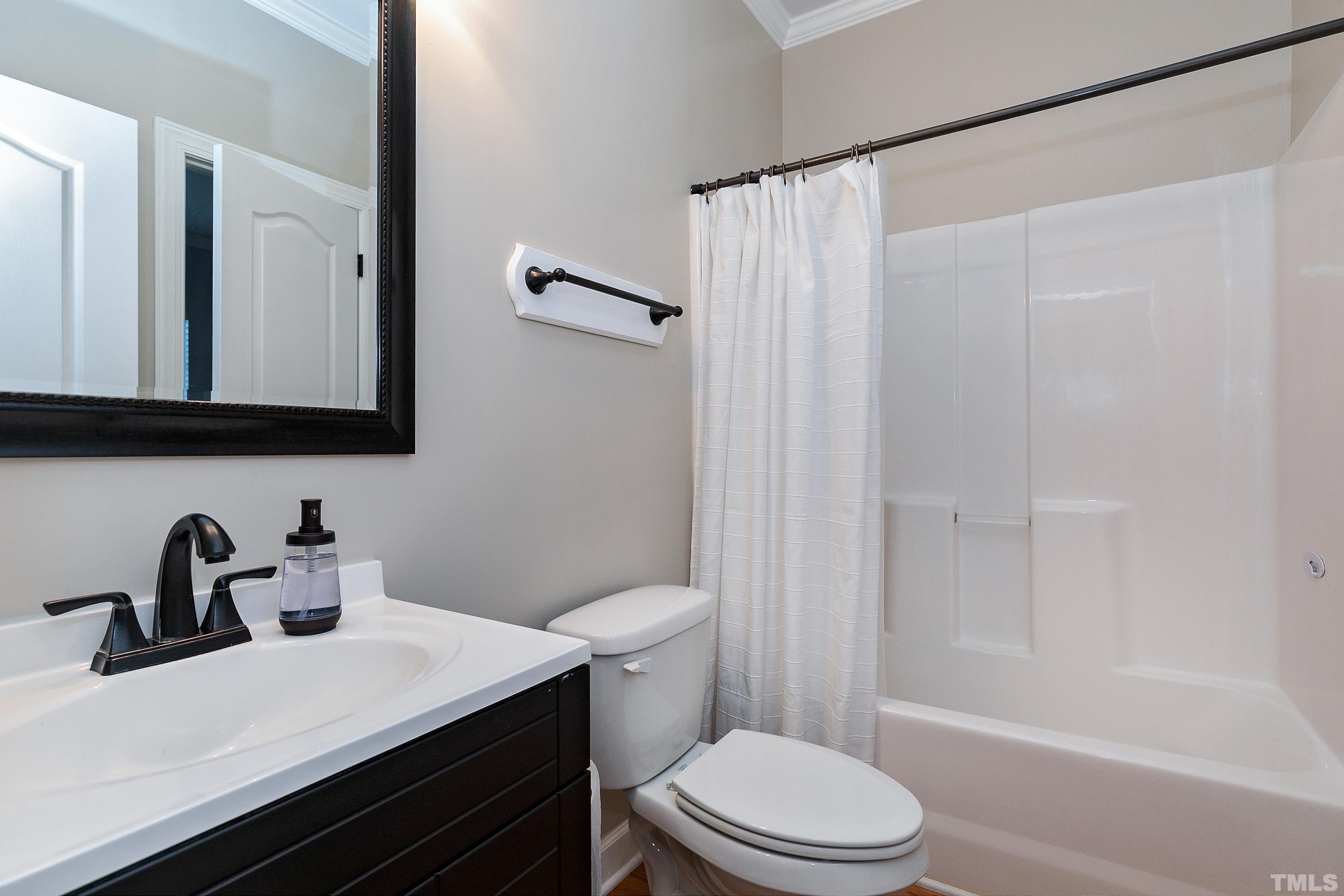 7025 Onslow Stephenson Road Willow Spring, NC 27592 - Photo 18 of 30 a bathroom with a sink a toilet and shower