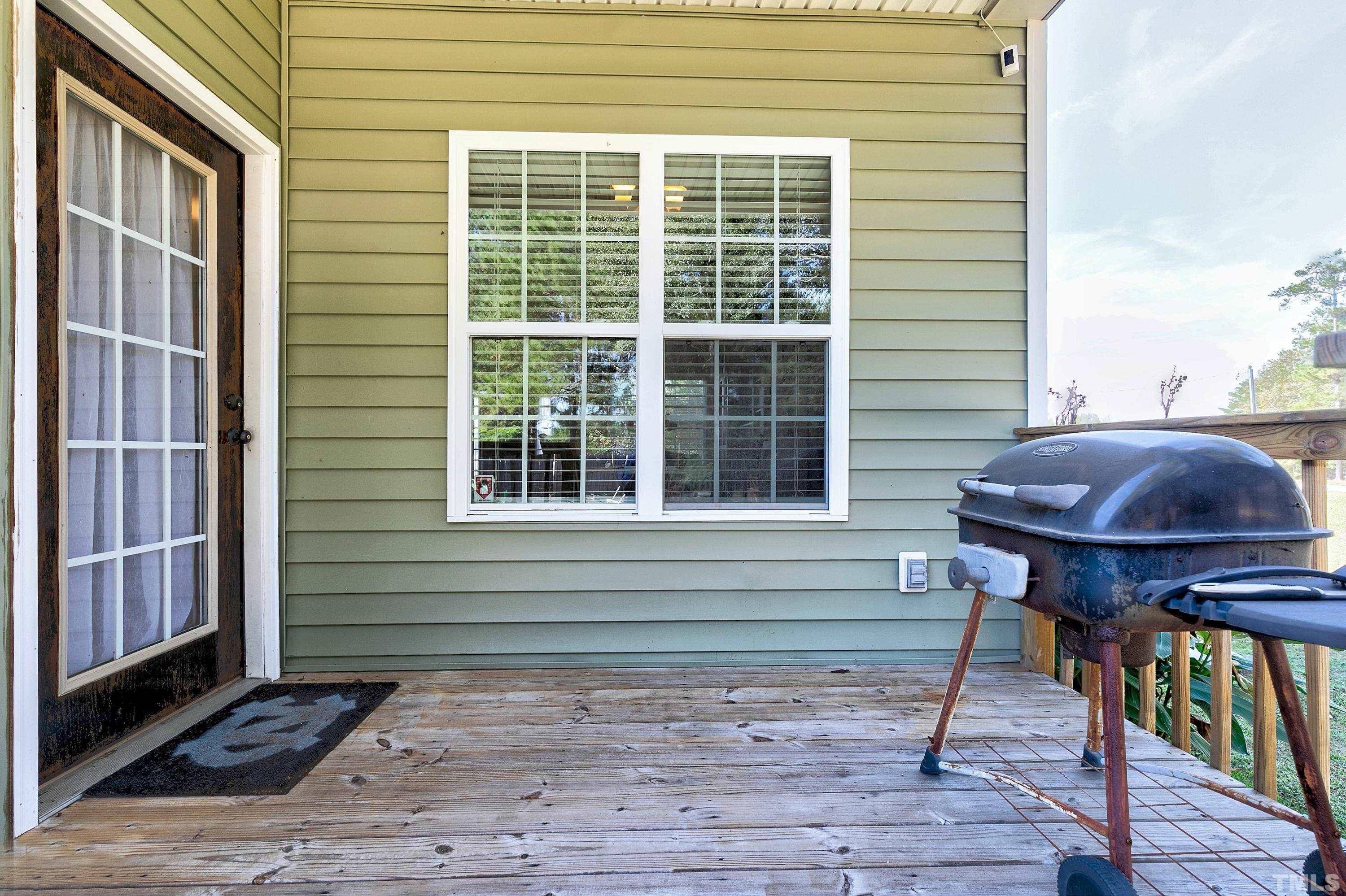 7025 Onslow Stephenson Road Willow Spring, NC 27592 - Photo 25 of 30 a view of house with wooden deck and furniture