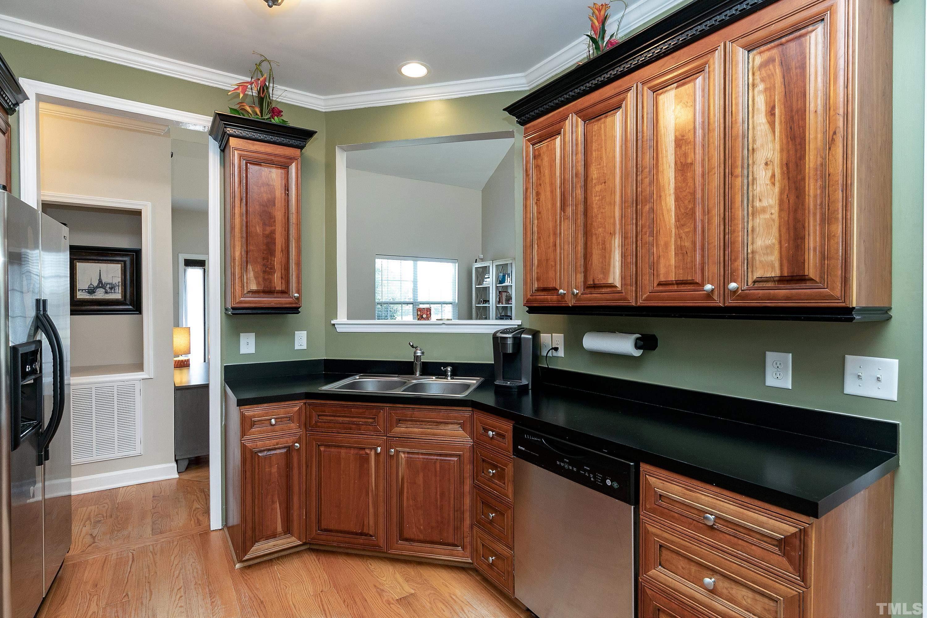 7025 Onslow Stephenson Road Willow Spring, NC 27592 - Photo 10 of 30 a kitchen with granite countertop wooden cabinets and a wooden floor