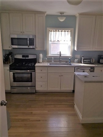 15 3rd Street Ayer, MA 01432 - Photo 6 of 8 a kitchen with stainless steel appliances granite countertop a stove a sink and a microwave