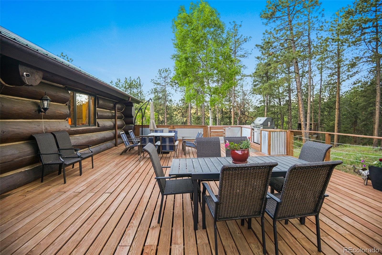 13434 Baird Road Conifer, CO 80433 - Photo 13 of 36 a view of a roof deck with dining table and chairs with wooden floor