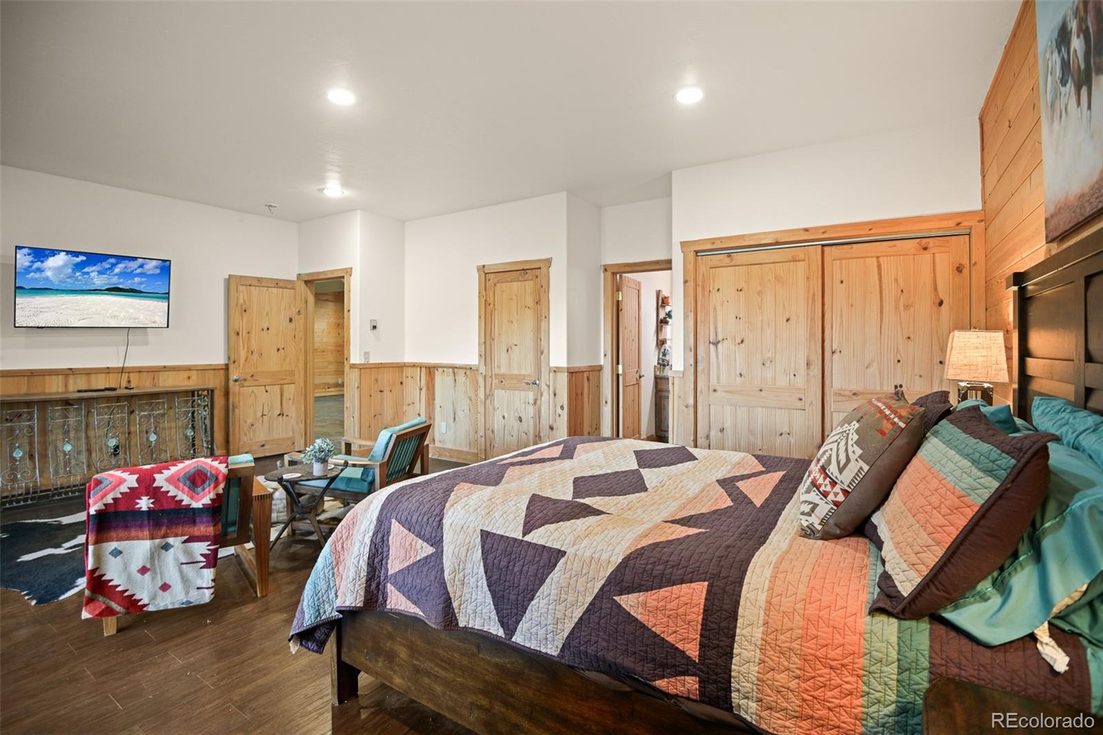 13434 Baird Road Conifer, CO 80433 - Photo 22 of 36 a bedroom with a bed and a chandelier