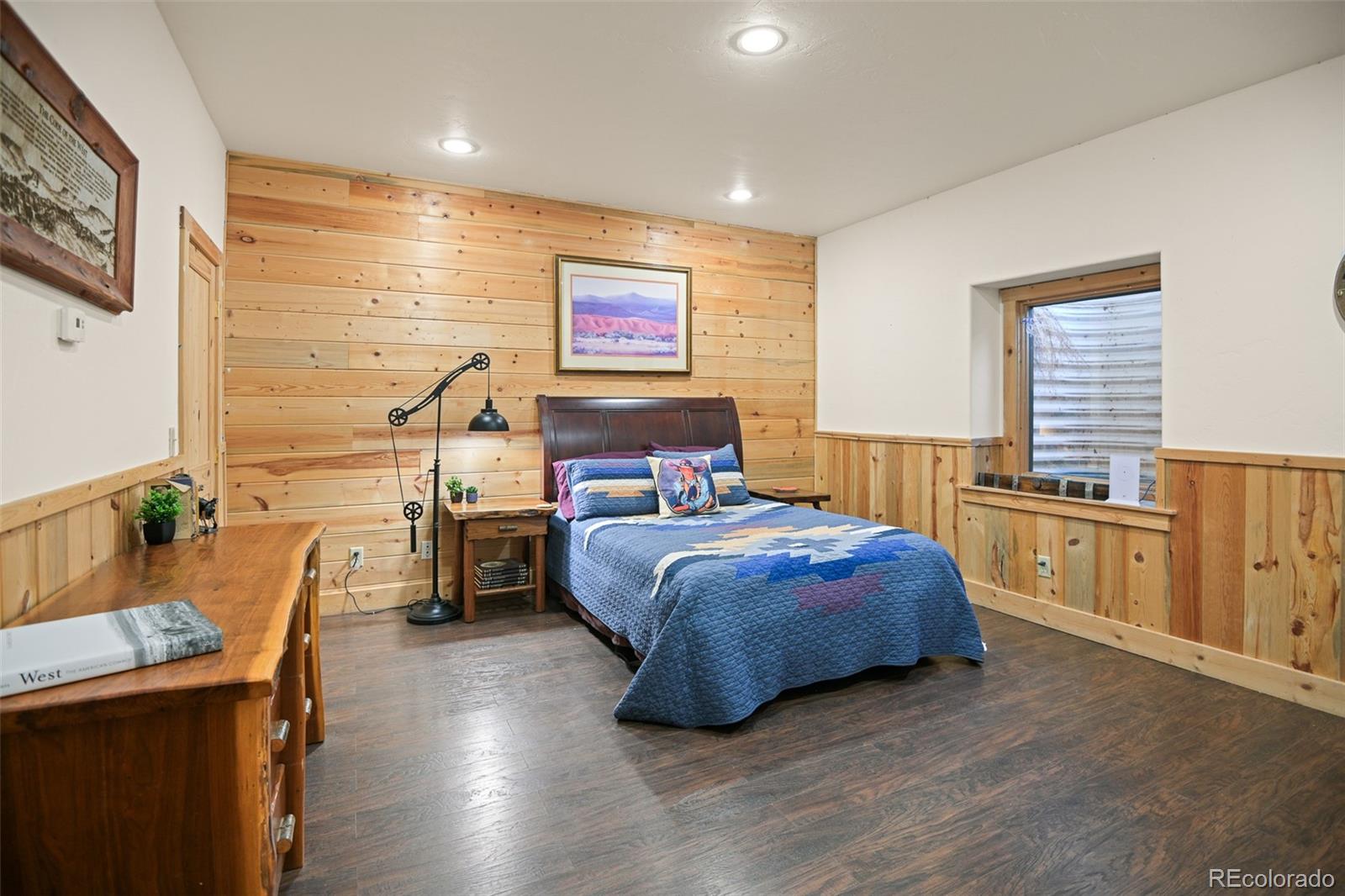 13434 Baird Road Conifer, CO 80433 - Photo 27 of 36 a bedroom with a bed and wooden floor