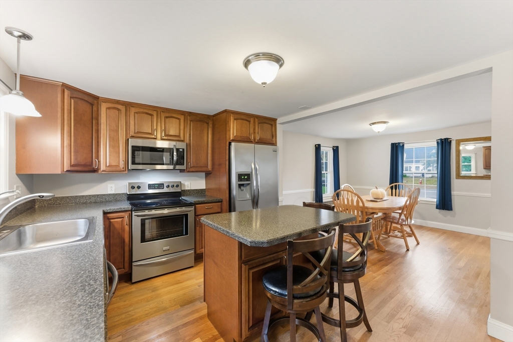 54 Churchill Road West Springfield, MA 01089 - Photo 7 of 42 a kitchen with stainless steel appliances granite countertop a stove top oven a sink dishwasher a dining table and chairs with wooden floor