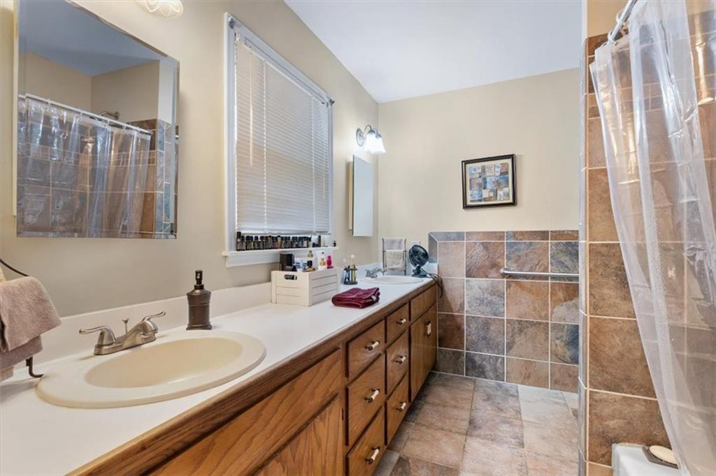 455 M M Sanders Road Buchanan, GA 30113 - Photo 28 of 65 a bathroom with a double vanity sink a mirror and a shower