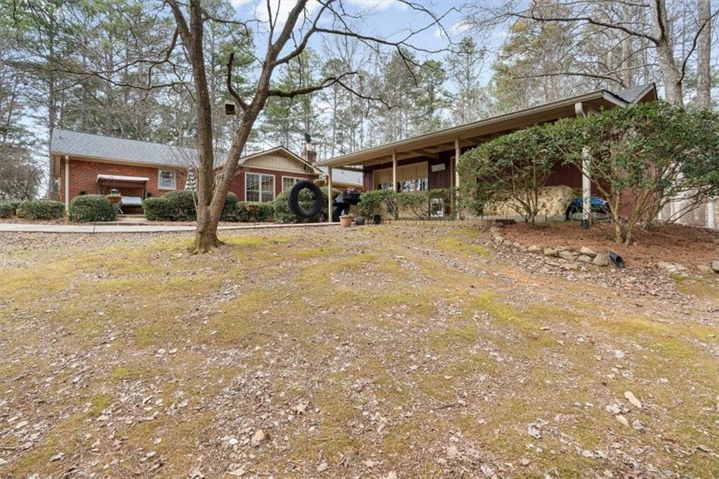 455 M M Sanders Road Buchanan, GA 30113 - Photo 3 of 65 a front view of a house with a yard and trees