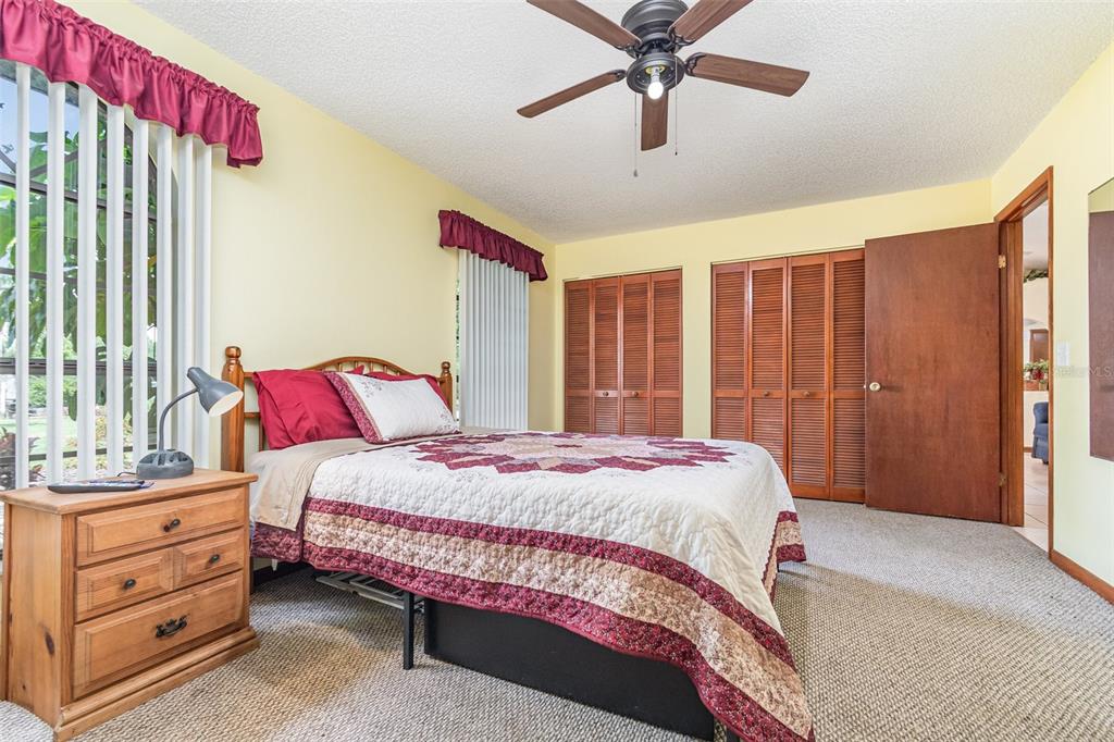 155 11th Avenue Osteen, FL 32764 - Photo 17 of 42 a bedroom with a bed and a chandelier