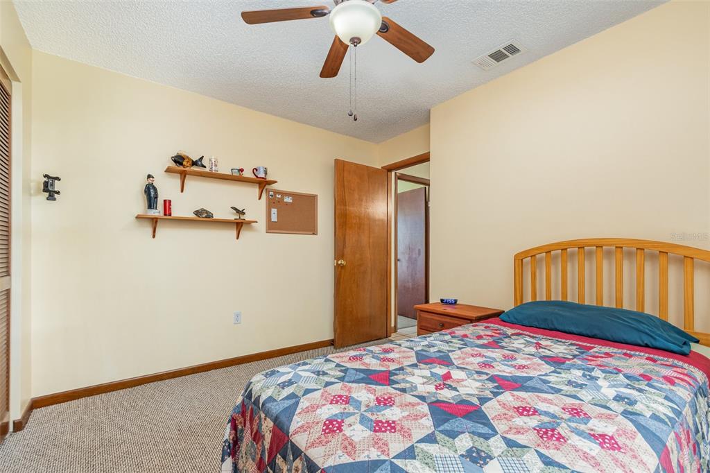 155 11th Avenue Osteen, FL 32764 - Photo 19 of 42 a bedroom with a bed and a chandelier