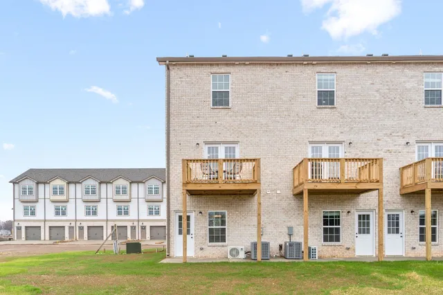 a front view of a residential apartment building with a yard