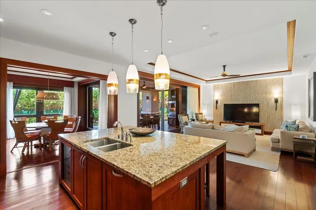 a kitchen with granite countertop a table chairs stove and wooden floor