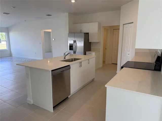 a kitchen with a sink a stove cabinets and wooden floor
