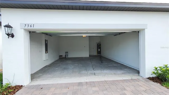 a view of house with a yard and potted plants