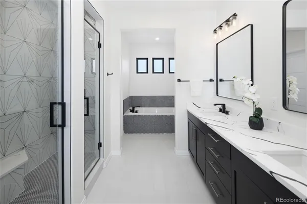 a spacious bathroom with a double vanity sink a mirror and shower