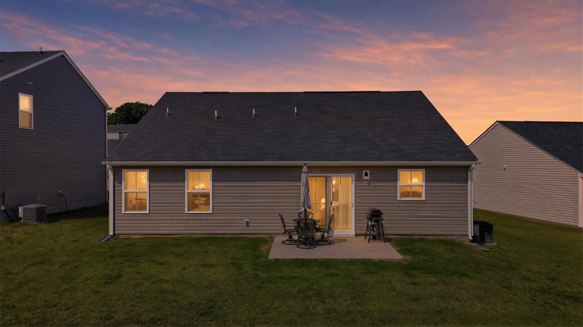 117 Alice Court Easley, SC 29642 - Photo 20 of 26 Relax and unwind on the backyard patio, complete with a grill for outdoor gatherings under a vibrant sunset sky.