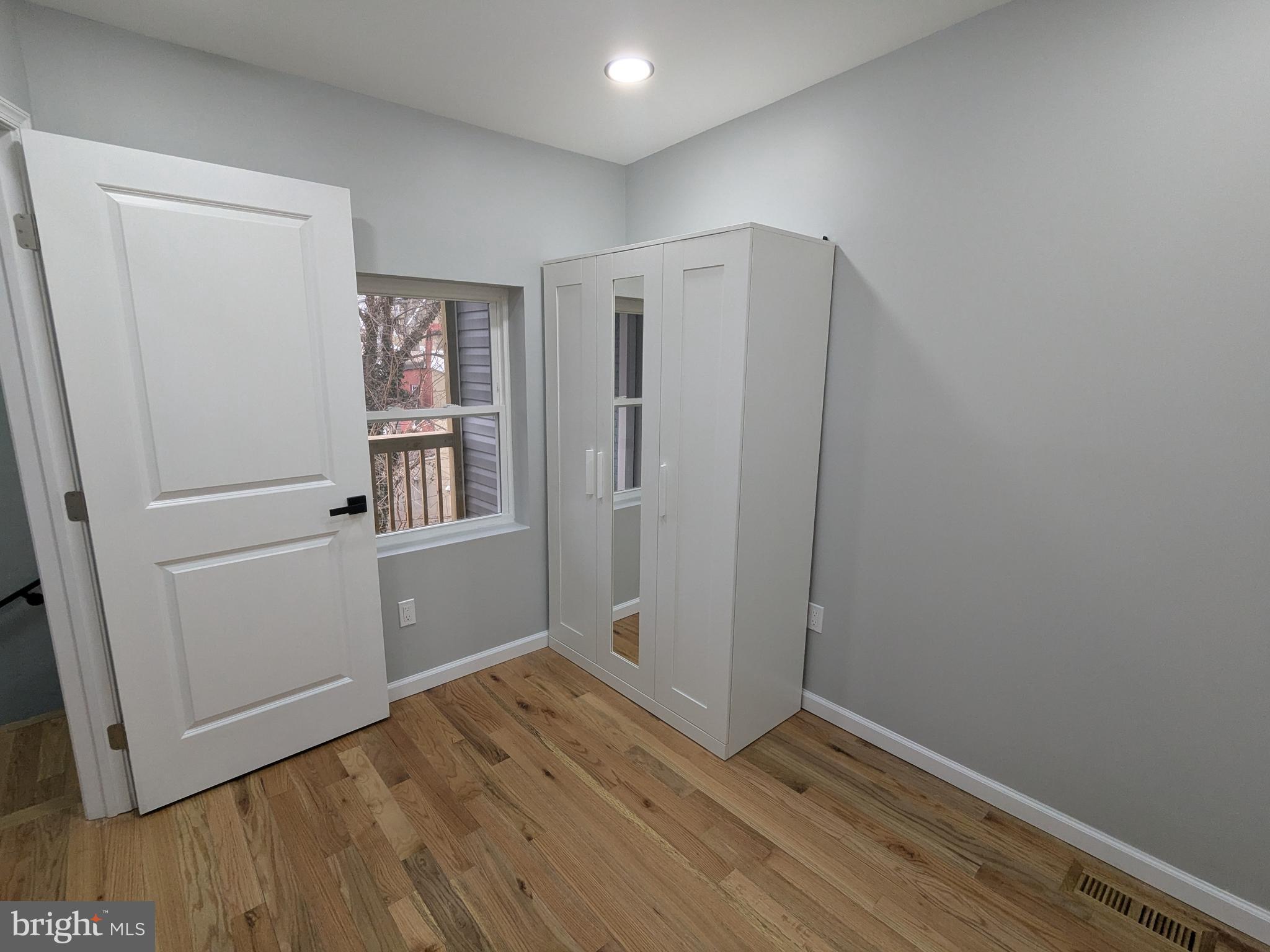 504 North Schroeder Street Baltimore, MD 21223 - Photo 18 of 32 a view of an empty room with wooden floor and a window