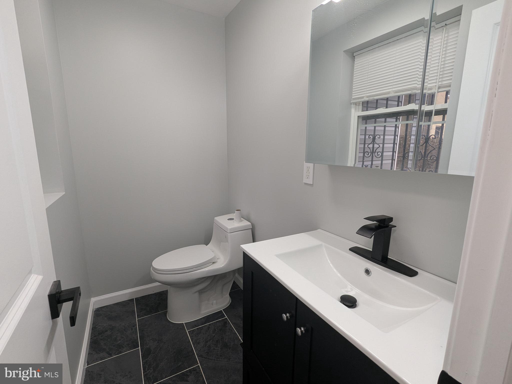 504 North Schroeder Street Baltimore, MD 21223 - Photo 6 of 32 a bathroom with a sink a toilet and a mirror