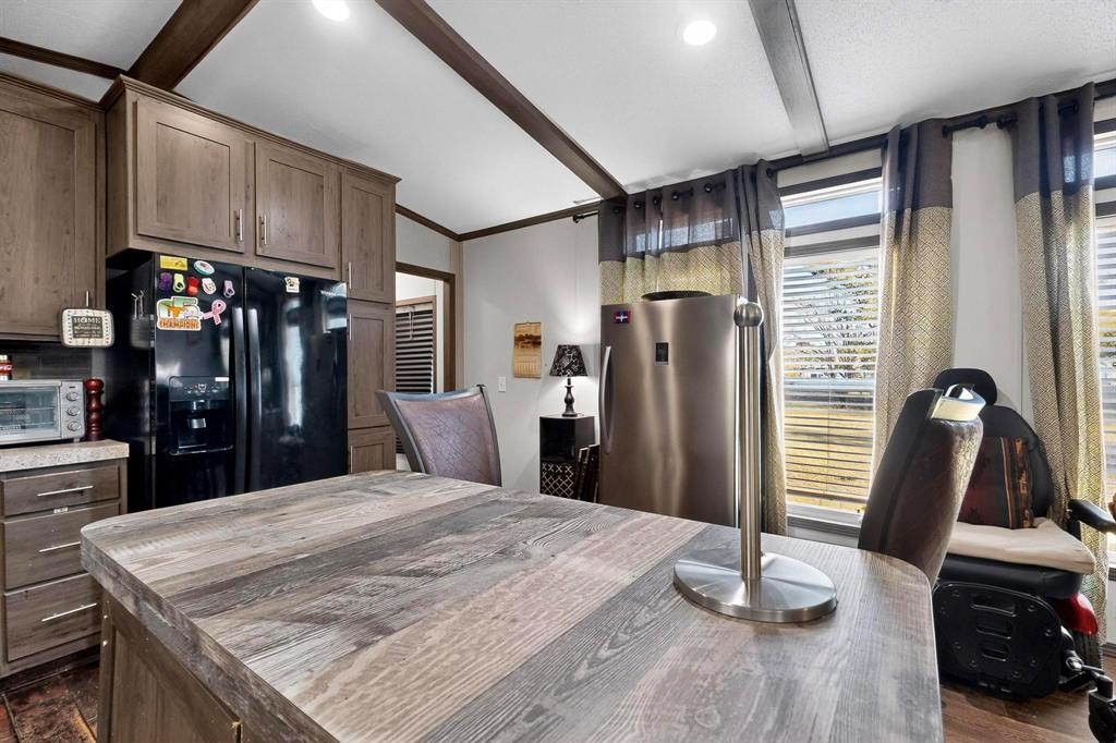 8450 North Farm To Market 148 Terrell, TX 75160 - Photo 14 of 38 Kitchen with black fridge with ice dispenser, freestanding refrigerator, beam ceiling, and ornamental molding