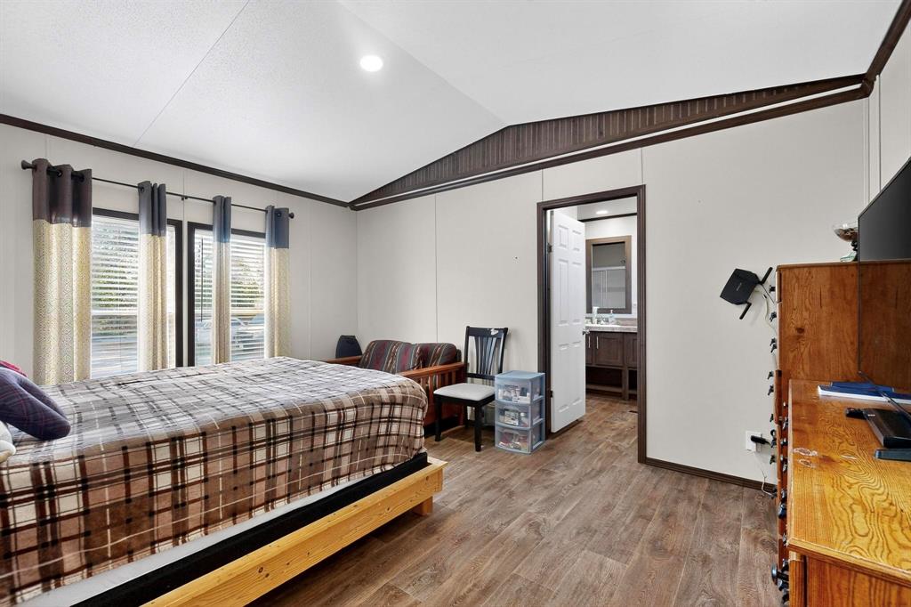 8450 North Farm To Market 148 Terrell, TX 75160 - Photo 19 of 38 Bedroom with lofted ceiling, wood finished floors, connected bathroom, and recessed lighting