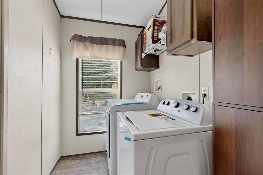 8450 North Farm To Market 148 Terrell, TX 75160 - Photo 29 of 38 Laundry area with cabinet space, washing machine and clothes dryer, light wood-style flooring, and crown molding