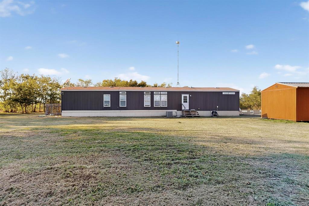 8450 North Farm To Market 148 Terrell, TX 75160 - Photo 32 of 38 Rear view of house featuring entry steps and a lawn