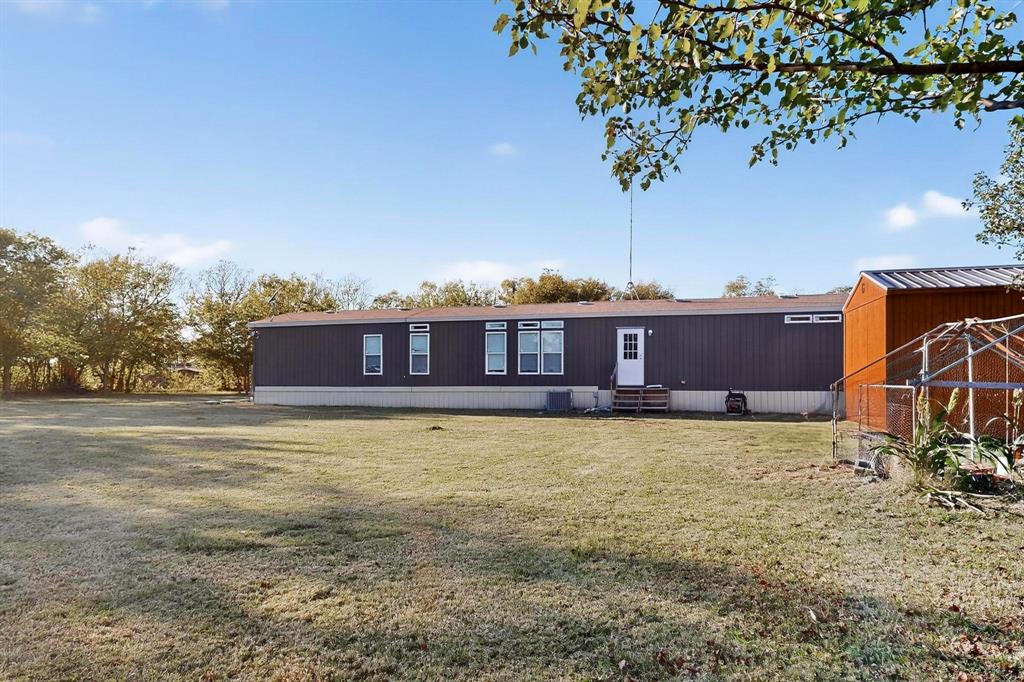 8450 North Farm To Market 148 Terrell, TX 75160 - Photo 34 of 38 Rear view of property with entry steps, a yard, and an outbuilding