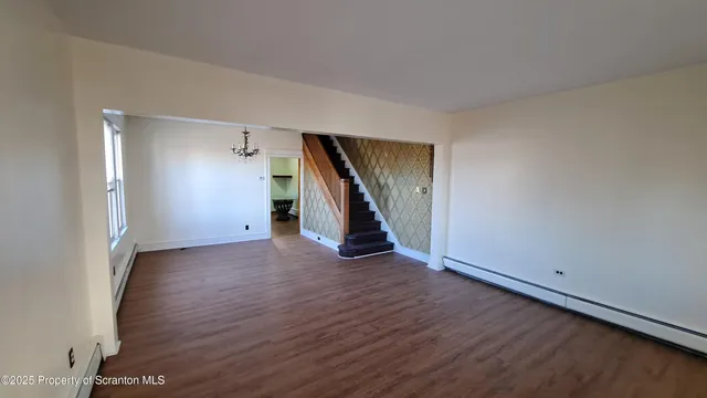 an empty room with wooden floor and stairs