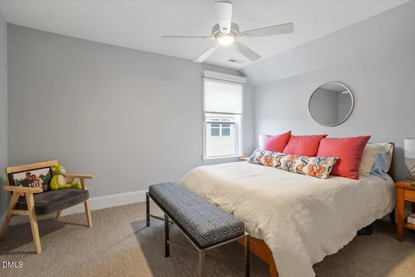 a bedroom with a bed a chandelier and a dresser