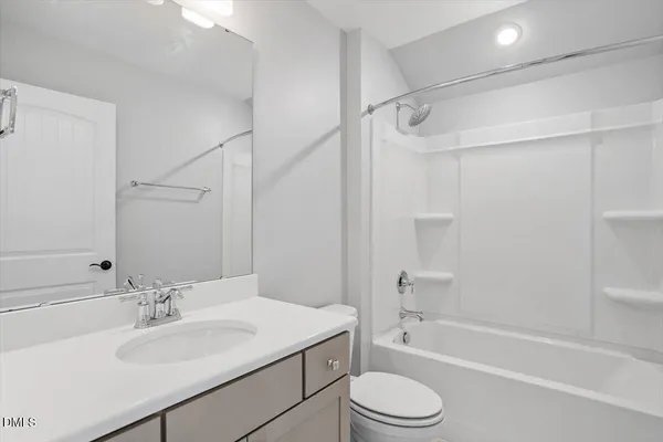 a bathroom with a sink toilet vanity and shower
