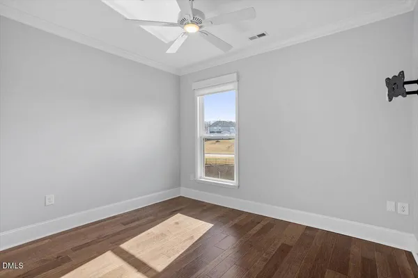 an empty room with a window and wooden floor